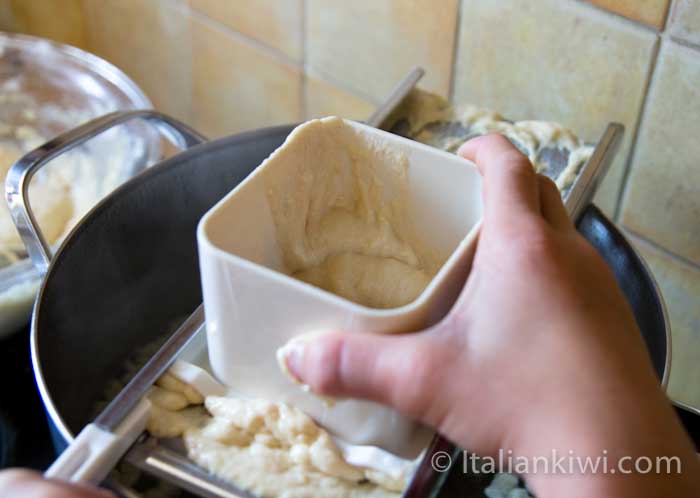 grating batter into the boiling water