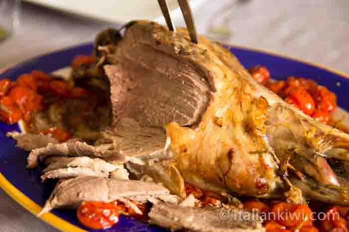 Roasted leg of lamb with tomatoes, garlic and rosemary